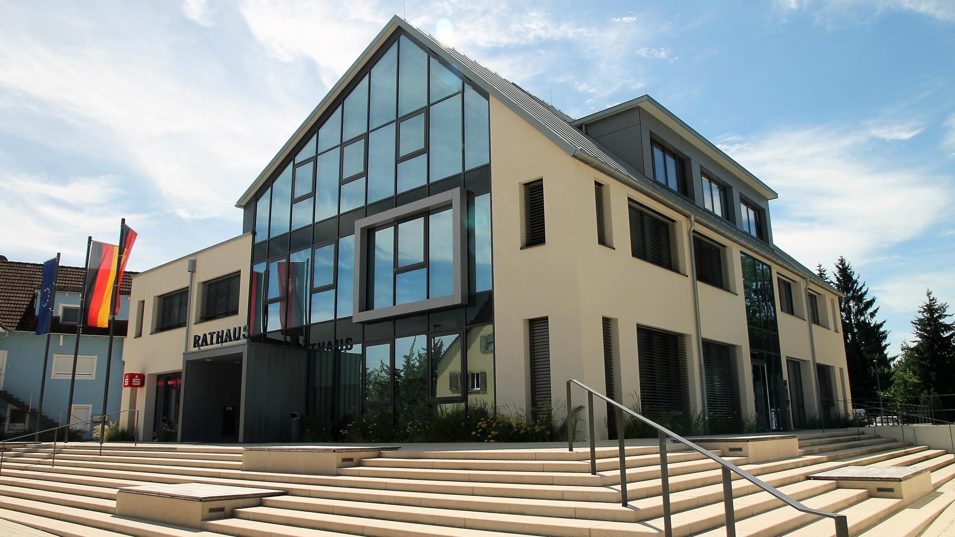 Ruster Rathaus Ostansicht des Rathauses mit großer Glasfront und über das Eck reichendem Treppenaufgang