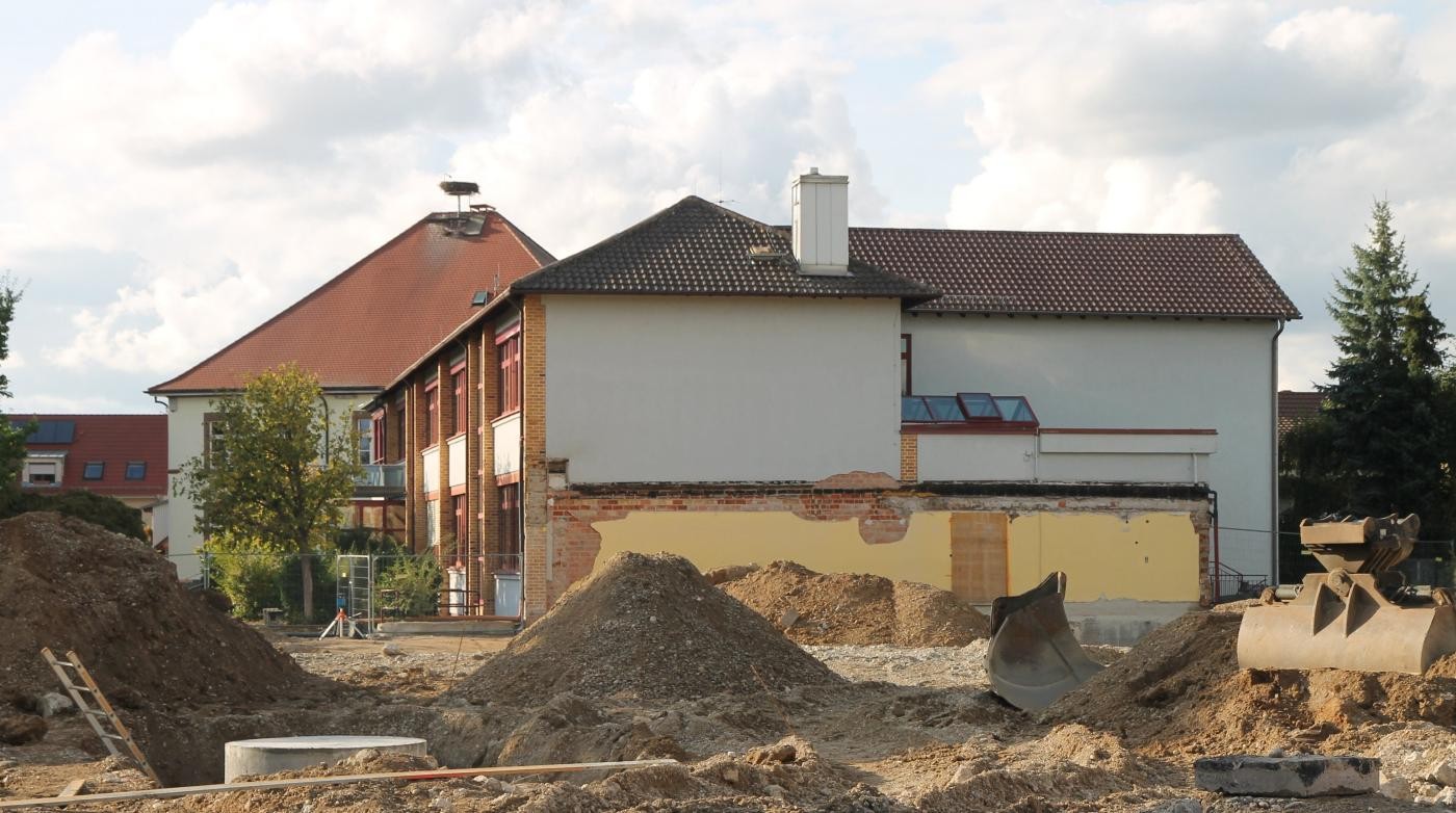 Abriss der alten Rheingießenhalle, man sieht den Bestand des Schulgebäudes