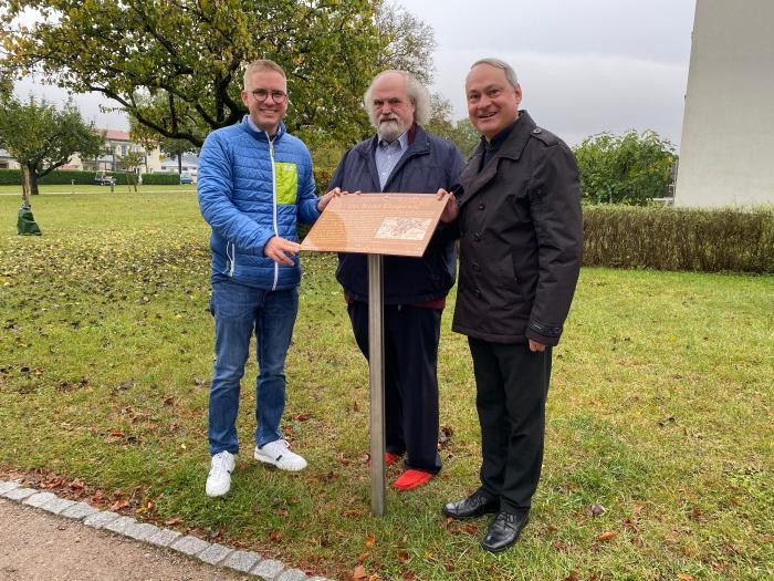 Bürgermeister Dr. Klare, Ortshistoriker Dr. Debacher und Pfarrer Rösch präsentieren die Infotafel am Klosgarten      