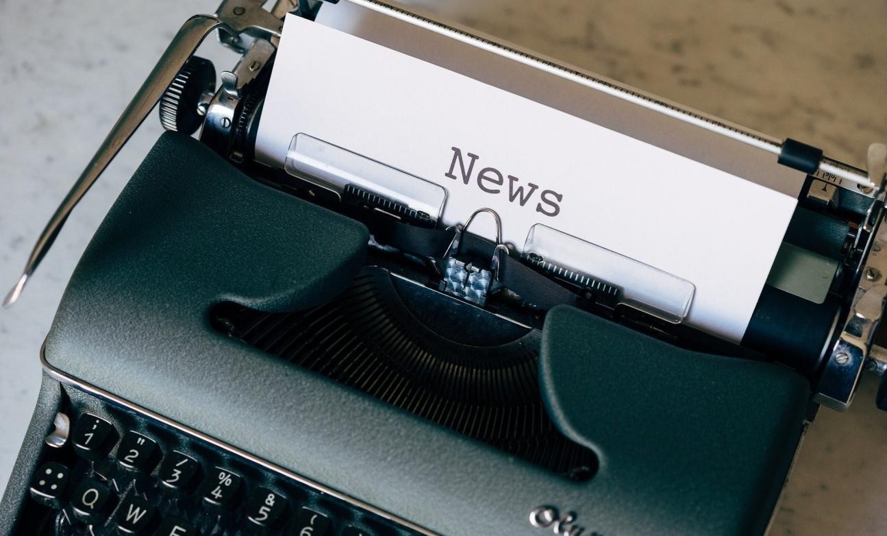 Schreibmaschine, in der ein mit "News" beschriebenes Blatt klemmt