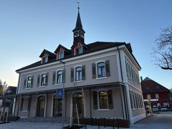 Altes Rathaus mit elegant beiger Fassade, lindgrünen Fensterläden und einem kleinen Türmchen auf dem Dach