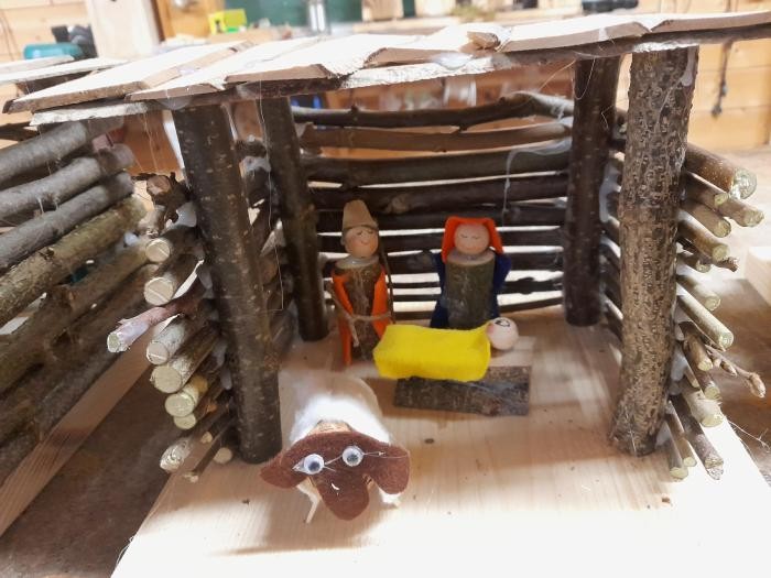 Weihnachtskrippe eine selbstgebastelte Weihnachtskrippe, größtenteils aus Ästen zusammengebaut, mit Josef, Maria, dem Jesukind in der Krippe und einem Schaf im Vordergrund