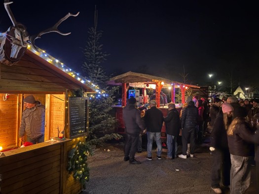 Thomasmarkt mehrere weihnachtlich geschmückte Hütten eines Weihnachtsmarktes, davor stehen Gäste