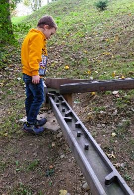Junge beobachtet seine Murmel in der Murmelbahn