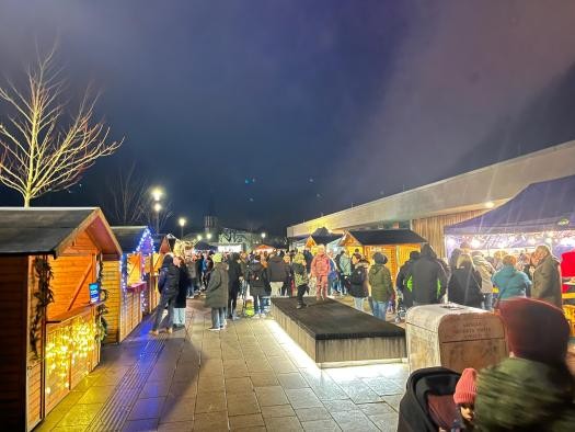 Zu sehen ist auf der rechten Seite die Rheingießenhalle und an beiden Seiten Markthütten mit Gästen dazwischen. Zu sehen ist auf der rechten Seite die Rheingießenhalle und an beiden Seiten Markthütten mit Gästen dazwischen.