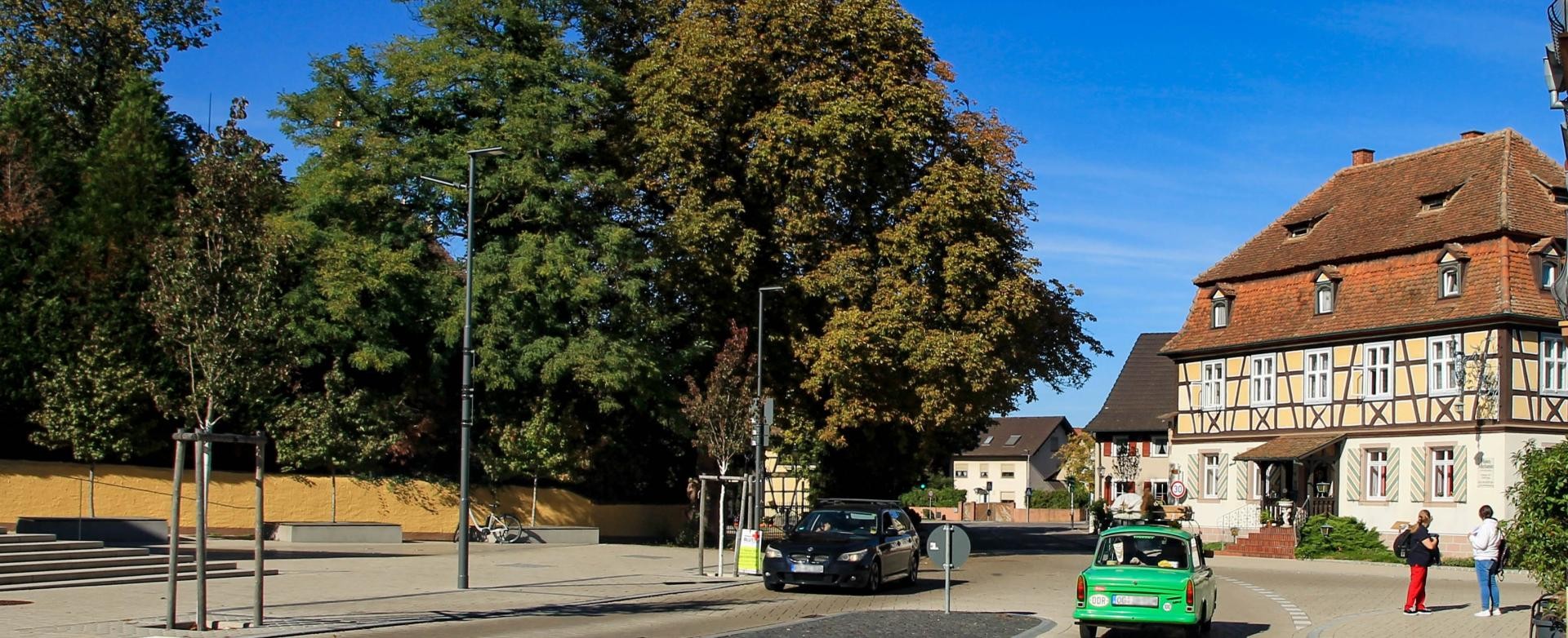 Verkehr Fischerstraße in Rust, zwei Autos passieren sich auf gleicher Höhe, links in Fahrtrichtung auf den Betrachter zu, ein schwarzes und wegfahrend ein grüner Trabbi