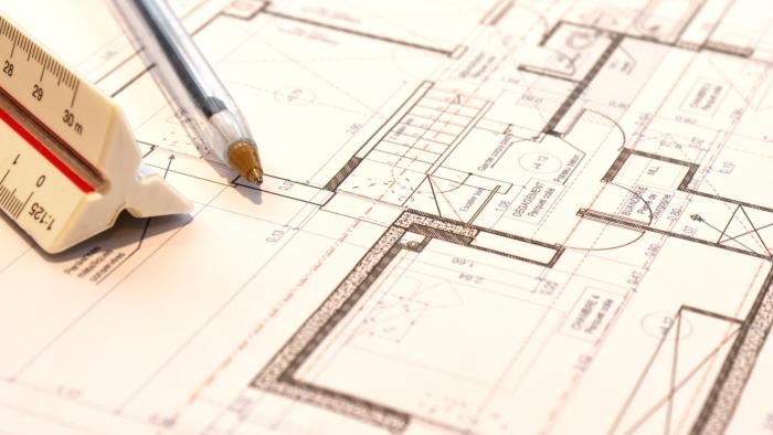 Mietpreisgebundene Wohnungen Grundrisspläne, auf ihnen liegt ein Kuli und ein dreidimensionales Lineal